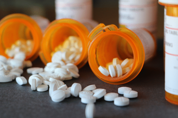Three open bottles of prescription medications side by side.